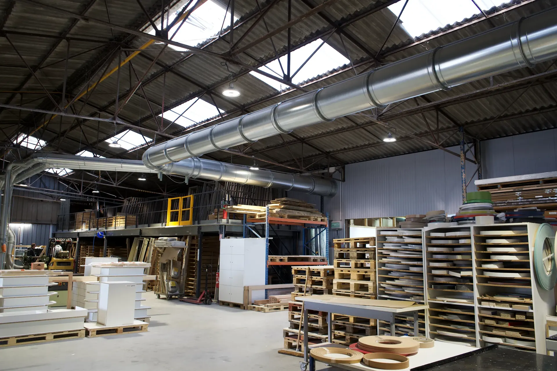 Atelier de menuiserie d'agencement BMA BY LEGRAND à Bray-sur-Seine : stock de chants, mezzanine et gaines d'aspiration