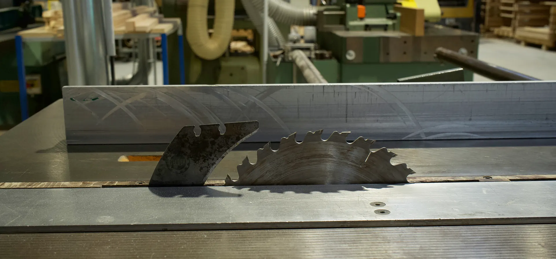 Lame de scie circulaire et son couteau diviseur en gros plan sur la table d'une scie à format